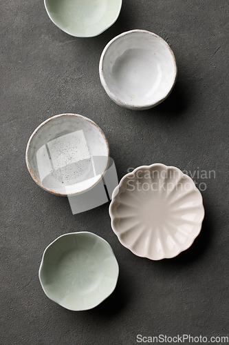 Image of various empty bowls on dark grey background