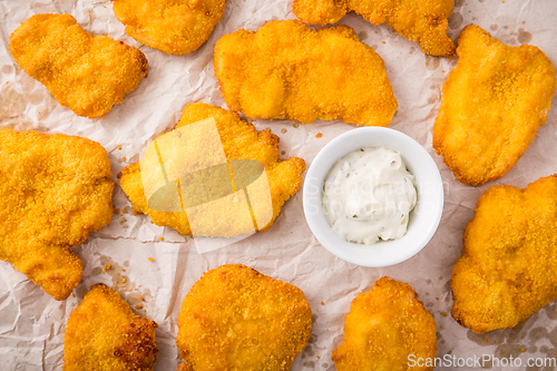 Image of Small chicken schnitzel on baking sheet with herb mayonnaise 