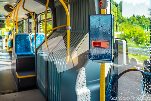 Image of Ticket validator with empty bus interior. Public transport in a city.