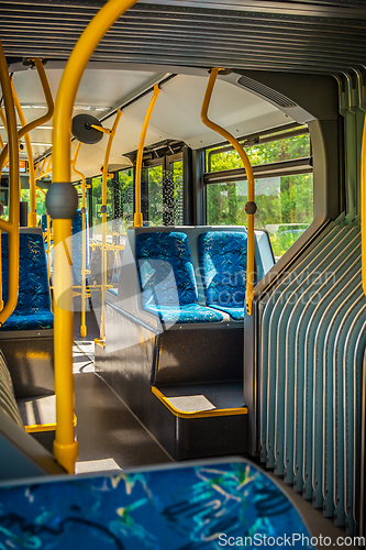 Image of Interior of a city bus. Empty bus interior. Bus with blue seats and yellow handrails