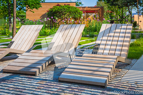 Image of Modern wooden deck chairs or chaise longues for patio or garden