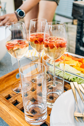 Image of Summer strawberry wine cocktails with healthy snacks on terrace