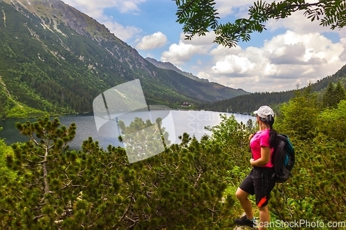 Image of A tourist admiring the mountain lake called Morskie Oko in Tatra mountains Poland