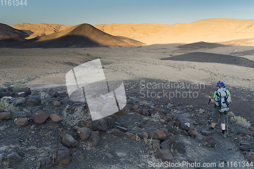 Image of Hiking tourist in desert trek adventure