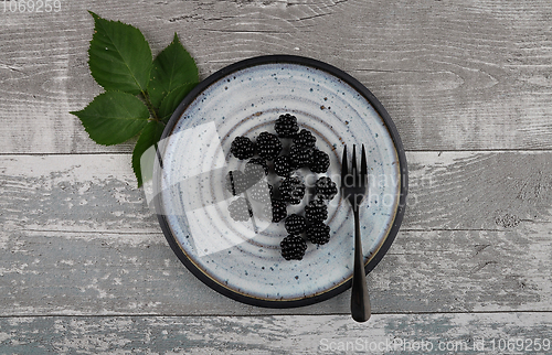 Image of Blackberries on plate and weathered wood