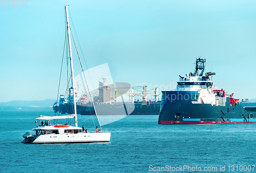 Image of Freight ships and white yacht