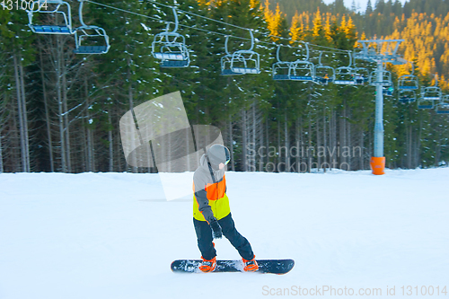 Image of Boy riding snowboard