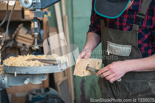 Image of Carpenters with electric drill machine drilling wooden board