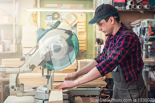 Image of Carpenter worker cutting wooden board