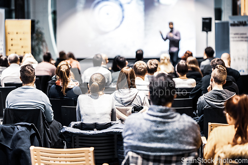 Image of Speaker giving a talk in conference hall at business event. Audience at the conference hall. Business and Entrepreneurship concept. Focus on unrecognizable people in audience