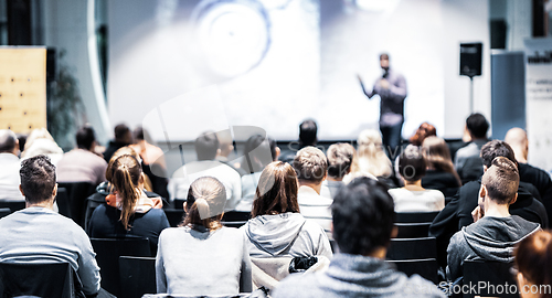 Image of Speaker giving a talk in conference hall at business event. Audience at the conference hall. Business and Entrepreneurship concept. Focus on unrecognizable people in audience