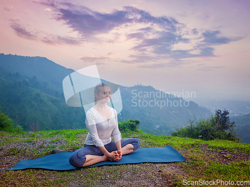 Image of Woman doing yoga asana Baddha Konasana outdoors