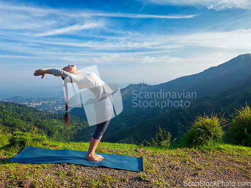 Image of Woman doing yoga Sun Salutation Surya Namaskar