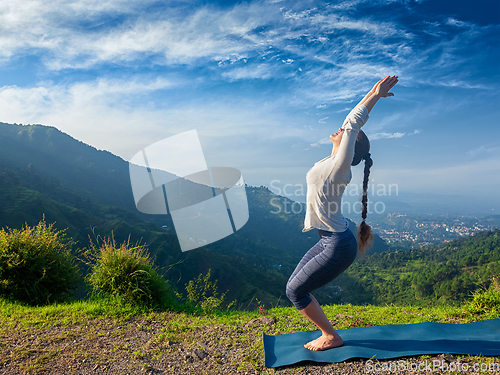 Image of Woman doing yoga asana Utkatasana outdoors