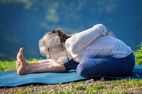 Image of Woman doing yoga asana outdoors