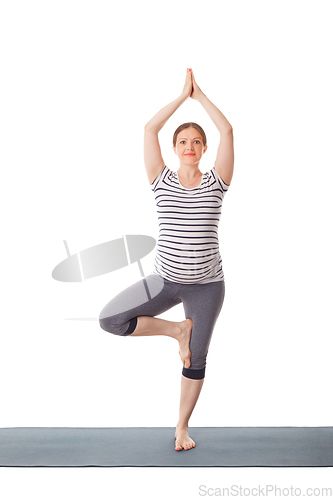 Image of Pregnant woman doing yoga asana Vrikshasana