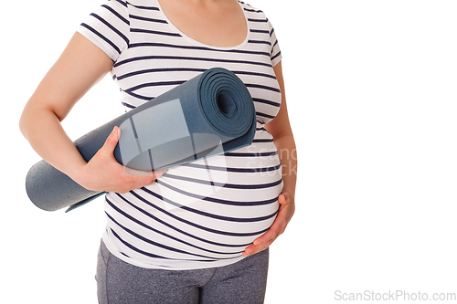 Image of Pregnant woman standing with yoga mat