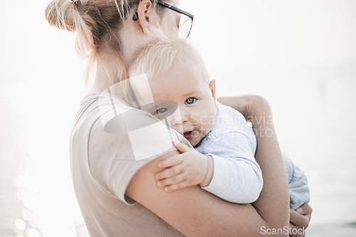 Image of Tender woman caressing her little baby boy infant child outdoors. Mother's unconditional love for her child