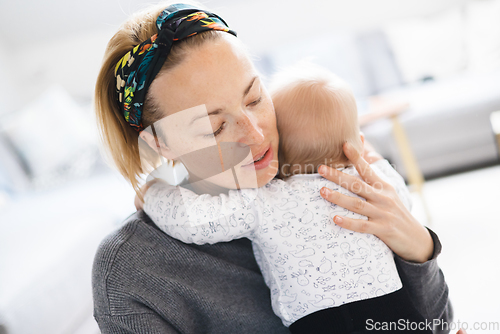 Image of Tender woman caressing her little baby boy infant child at home. Mother's unconditional love for her child