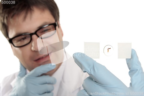 Image of Scientist thinking over a microscope slide