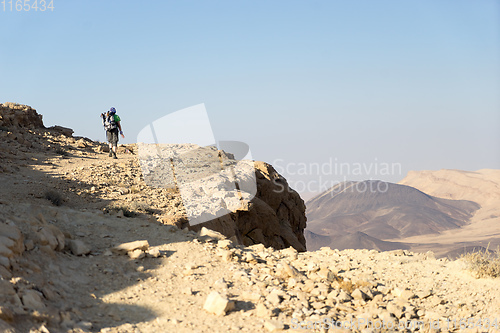 Image of Hiking tourist in desert trek adventure