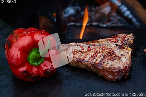 Image of Grilled T-Bone Steak on serving board on wooden background