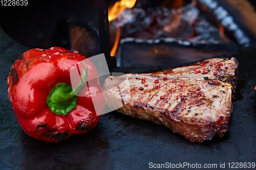 Image of Grilled T-Bone Steak on serving board on wooden background