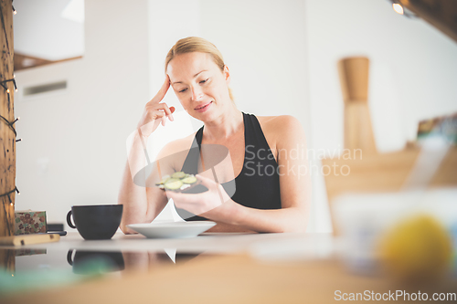 Image of Beautiful sporty fit young pregnant woman having a healthy snack in home kitchen. Healty lifestyle concept.