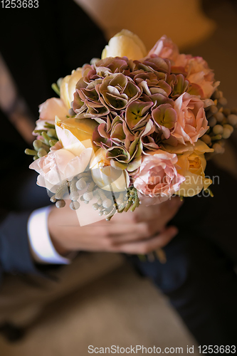Image of Groom holding in hands delicate, expensive, trendy bridal wedding bouquet of flowers