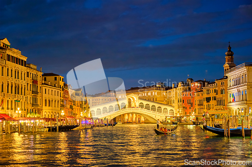 Image of Rialto bridge Ponte di Rialto over Grand Canal at night in Venice, Italy