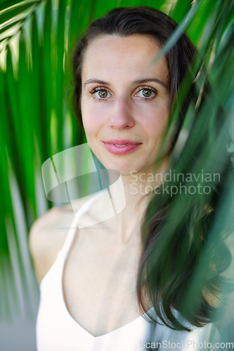 Image of Young beautiful natural cheerful woman with healthy face and skin in exotic greenery. Closeup fresh face of attractive girl. Summer model. Natural beauty concept