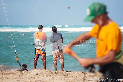 Image of Active sporty people enjoying kitesurfing holidays and activities on perfect sunny day on Cabarete tropical sandy beach in Dominican Republic.