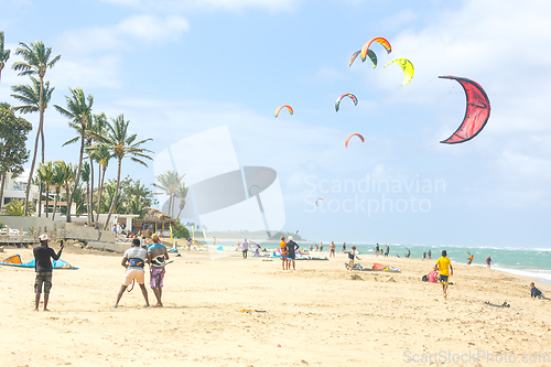 Image of Crowd of active sporty people enjoying kitesurfing holidays and activities on perfect sunny day on Cabarete tropical sandy beach in Dominican Republic.