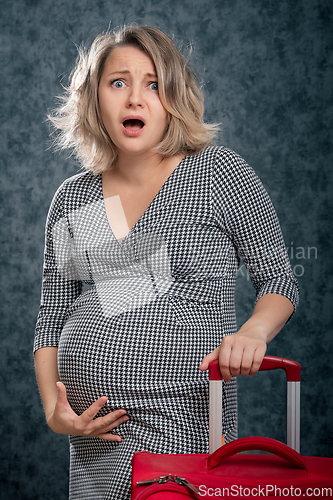 Image of Pregnant woman with suitcase for maternity hospital