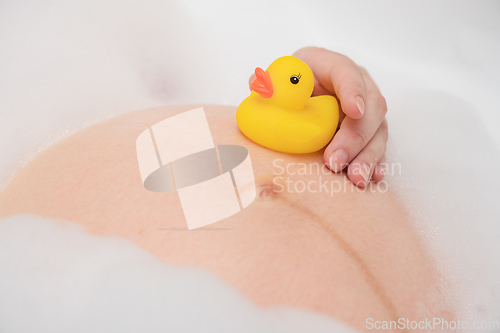 Image of Pregnant woman in bath with toy