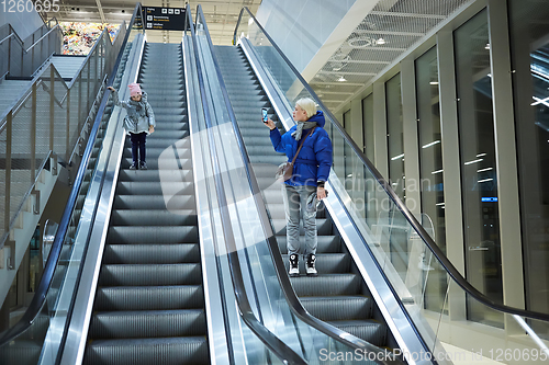 Image of Mother and child together on escalator background. Terminal, airport travel, love care.