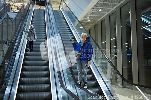 Image of Mother and child together on escalator background. Terminal, airport travel, love care.