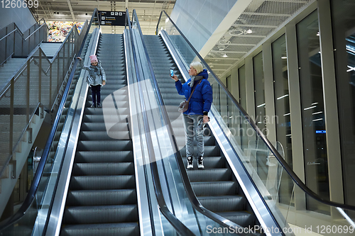 Image of Mother and child together on escalator background. Terminal, airport travel, love care.