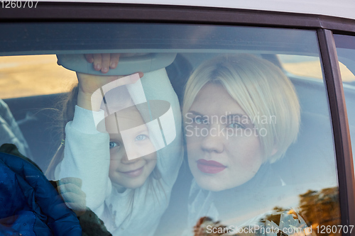 Image of Family concept. Portrait of mother and daughter through the glass of a car