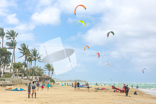 Image of Crowd of active sporty people enjoying kitesurfing holidays and activities on perfect sunny day on Cabarete tropical sandy beach in Dominican Republic.