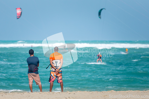 Image of Active sporty people enjoying kitesurfing holidays and activities on perfect sunny day on Cabarete tropical sandy beach in Dominican Republic.