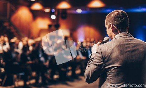 Image of Public speaker giving talk at Business Event.