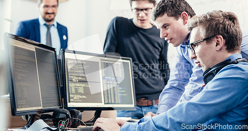 Image of Startup business problem solving. Software developers working on desktop computer.