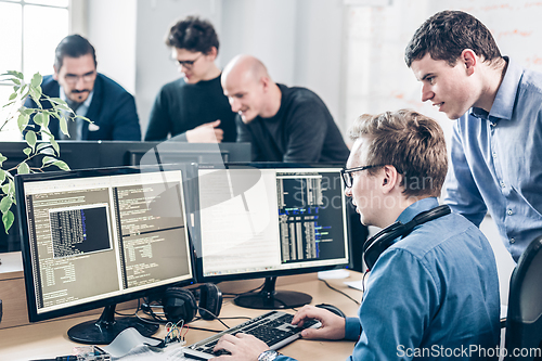 Image of Startup business problem solving. Software developers working on desktop computer.