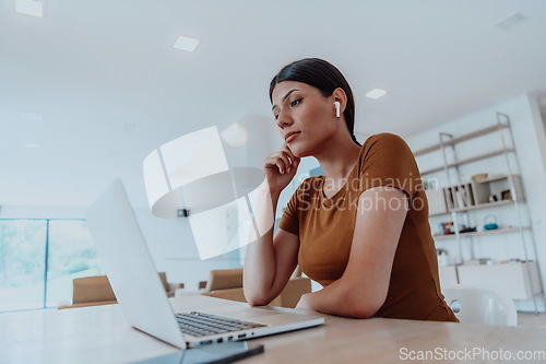 Image of Woman sitting in living room using laptop look at cam talk by video call with business friend relatives, head shot. Job interview answering questions.