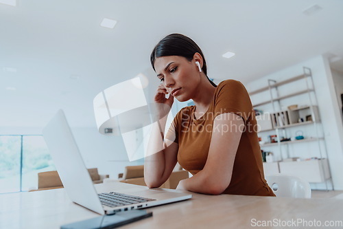 Image of Woman sitting in living room using laptop look at cam talk by video call with business friend relatives, head shot. Job interview answering questions.