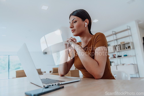 Image of Woman sitting in living room using laptop look at cam talk by video call with business friend relatives, head shot. Job interview answering questions.