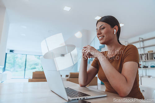 Image of Woman sitting in living room using laptop look at cam talk by video call with business friend relatives, head shot. Job interview answering questions.