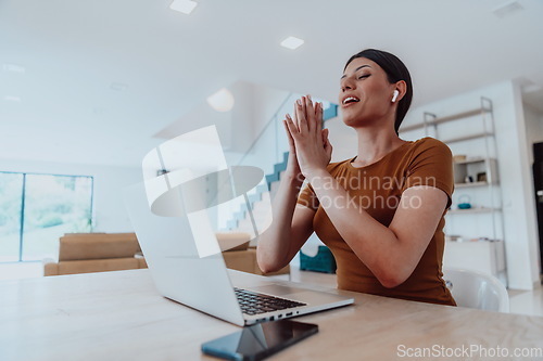 Image of Woman sitting in living room using laptop look at cam talk by video call with business friend relatives, head shot. Job interview answering questions.