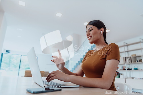 Image of Woman sitting in living room using laptop look at cam talk by video call with business friend relatives, head shot. Job interview answering questions.